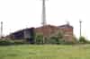 The VLF Transmitter Building (C) and Generator Hall. The masts at the four corners of the building carry the feeds for the earth mat around the building.Note the aerial lead out insulator on the roof (Nick Catford)