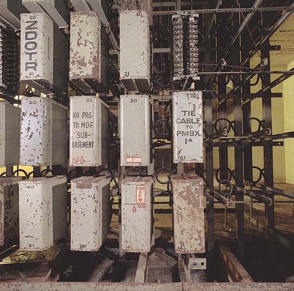 Dust covers over fuse mountings on the Main Distribution Frame (MDF). Note one cover has the lettering CWR (Cabinet War Room) and another refers to 100 pairs (of wires) to the MDF in the sub-basement. A smaller MDF can still be found in the sub-basement (Nick Catford)