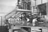 A view of the plotting room in WW2 looking east. Two officers are standing on the viewing platform discussing the plot. Note the telephone PMBX in the background under the stairs, also the cabin shown has no desk under the window