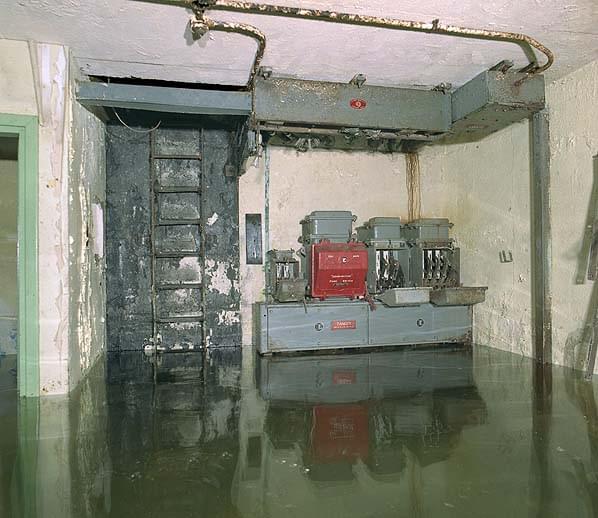 The generator room with the toilet cubicle on the far left, personnel ladder in the centre and the three phase switch panel on the right. Note the bus bar chamber above the panel (Nick Catford)