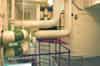 The AC plant room seen from the upper level. The cooled water header tank is located in the room in the centre behind the pipes. This feeds the Baudelot heat exchanger (Nick Catford)