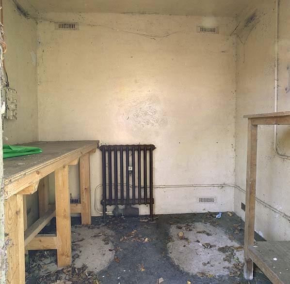 Inside one of the three remaining hutches. The fissile core vessel stood in an aperture on the floor in front of the radiator. The two patches of concrete on the floor indicate this hutch was designed to house two fissile cores (Nick Catford)