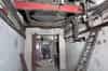 Looking into one of the two plant rooms near the bottom of the south lift shaft. A mercury vapour rectifier can be seen in the metal cabinet against the far wall on the right. In the foreground the exhaust fan sits at the bottom of the ventilation shaft (Nick Catford)