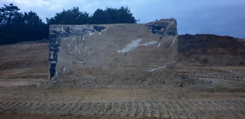 The post once all the surrounding ground had been removed.  In the images you can see the cable inlet pipe, whats left of the doglegged air vent at the rear of the bunker , a slight bulge at the top where the access shaft was filled in and covered over and the black stuff is the waterproof tanking.   (Jack Watkins)