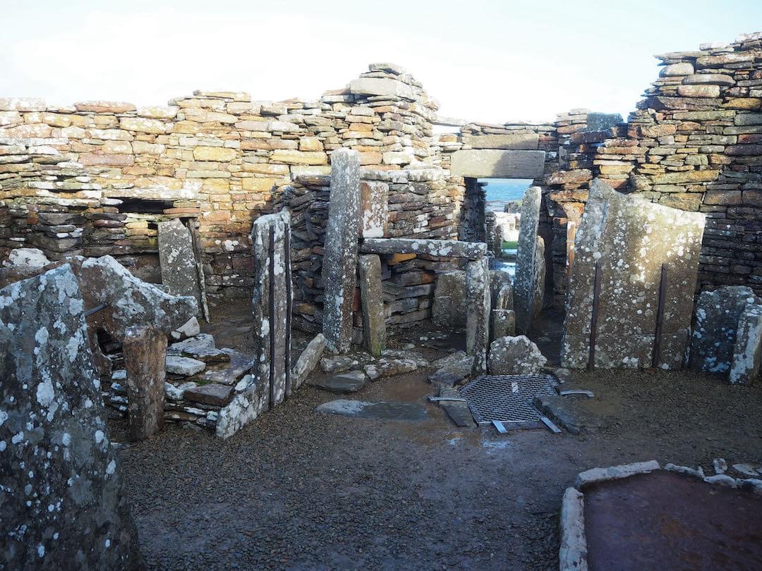 View across interior of broch. Stairs to (destroyed) second level adjacent to doorway. Cistern in centre with grille over. (Neil Iosson)