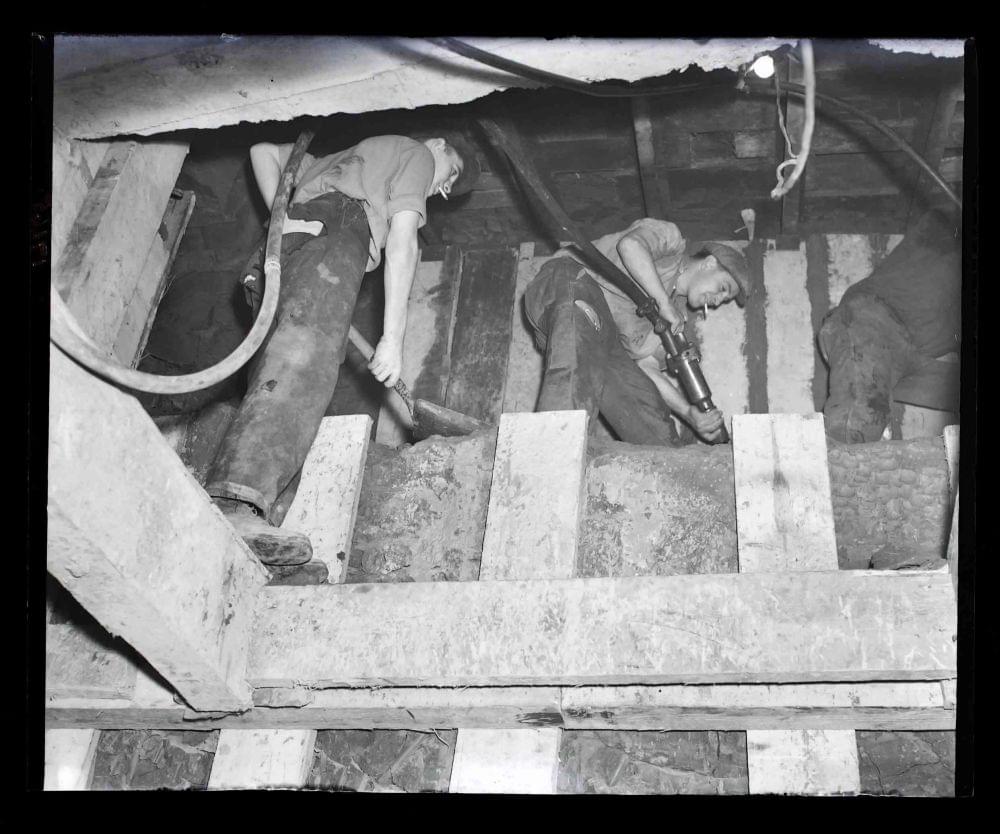 Kingsway Telephone Exchange, Holborn, Tunnel Scheme 2147 construction workers cutting clay to form opening between 16 foot 6 inch and 25 foot diameter tubes. (1952) (www.digitalarchives.bt.com - TCB 417/E 17665)