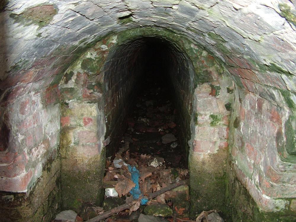 The central passage beneath the grotto. This collected spring water but is now generally dry. (© John Phillips / Friends of Honeywood Museum)